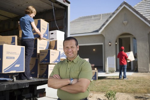Professional movers carrying furniture through a Belgravia property